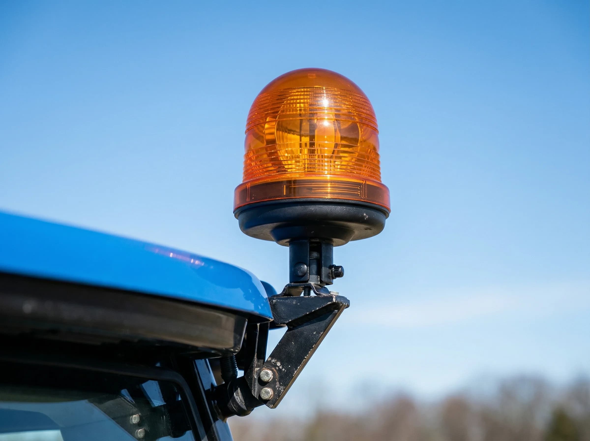 Amber rotating beacon mounted on the roof of a tractor cab