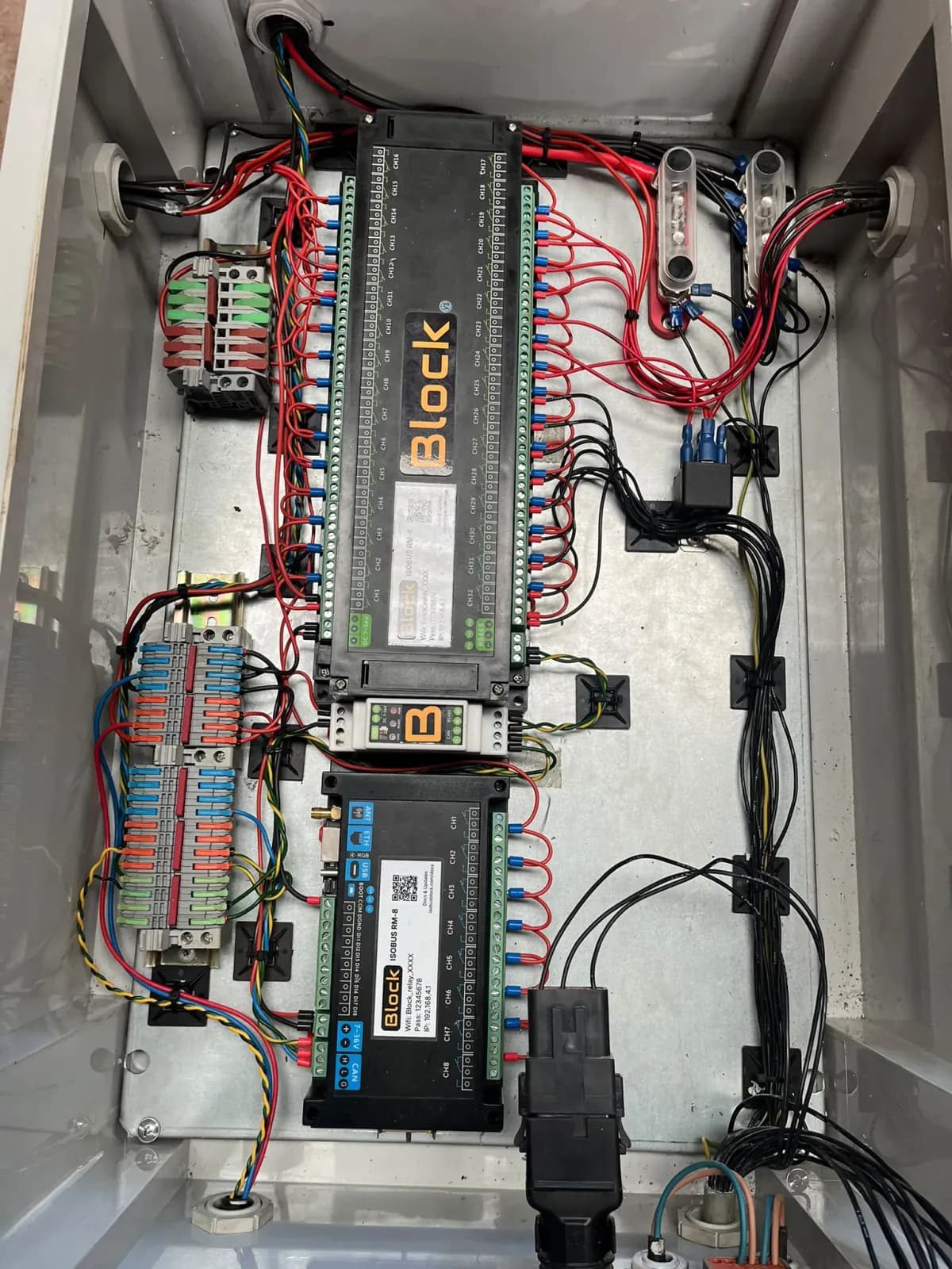 A 32-channel and an 8-channel ISOBUS Block module on the back plate of a customer's own enclosure, wired through push-in terminal blocks and inline fuse holders