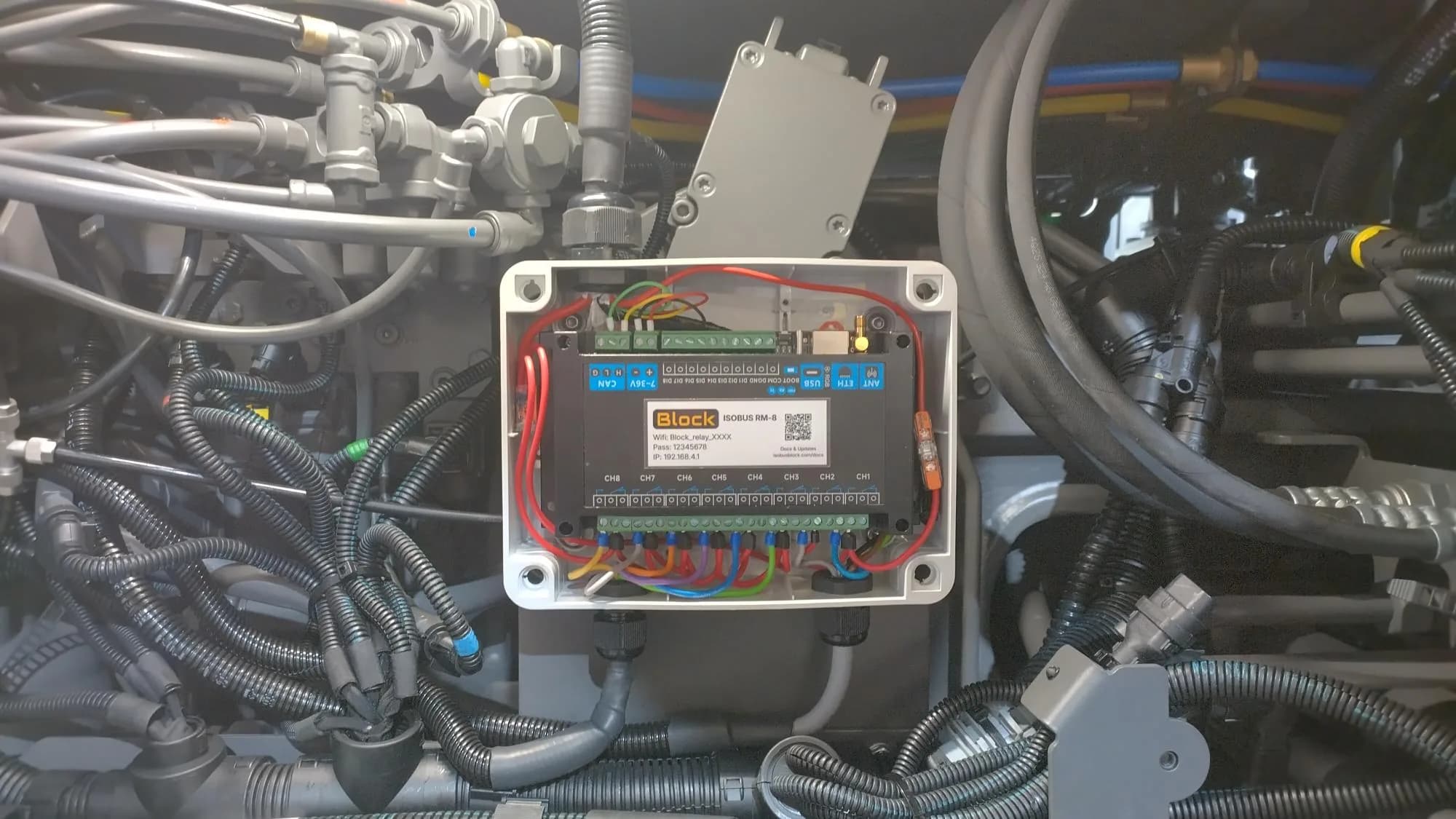 Finished wiring: eight relay leads on the CH1 to CH8 terminal block, red supply feed on the shared COM rail, ISOBUS supply and CAN across the top header