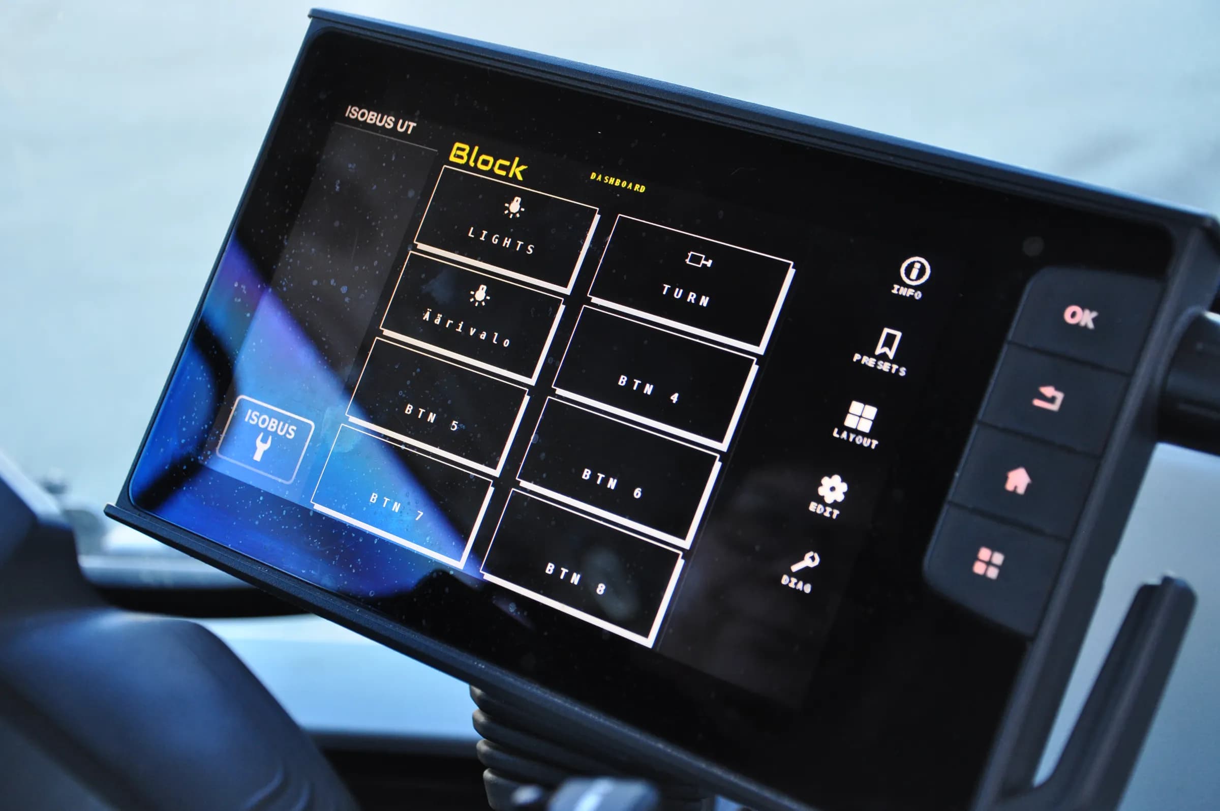 The ISOBUS Block dashboard running on a tractor's Virtual Terminal, relay buttons laid out across the screen