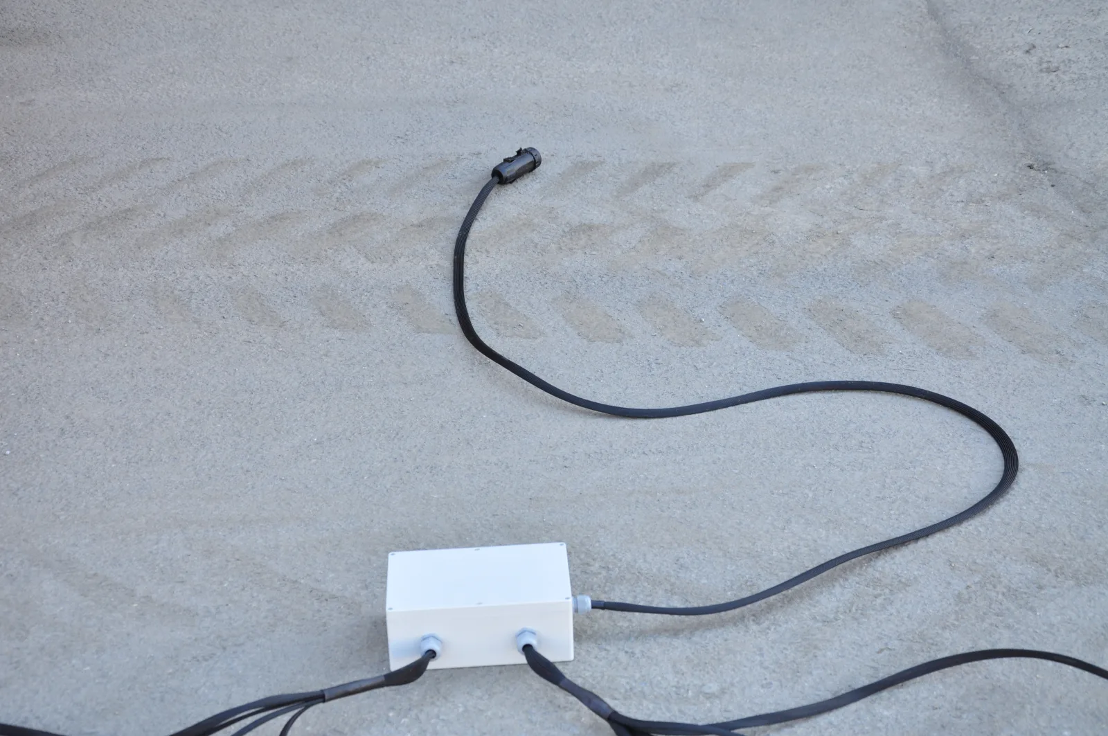 Single ISOBUS cable running from the implement-mounted enclosure across the ground toward the tractor's rear external ISOBUS connector