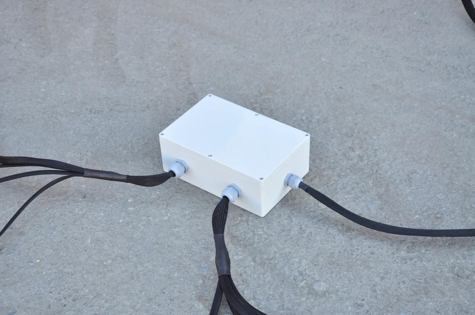 White IP-rated weatherproof enclosure containing the ISOBUS Block, with cables exiting through cable glands on multiple sides
