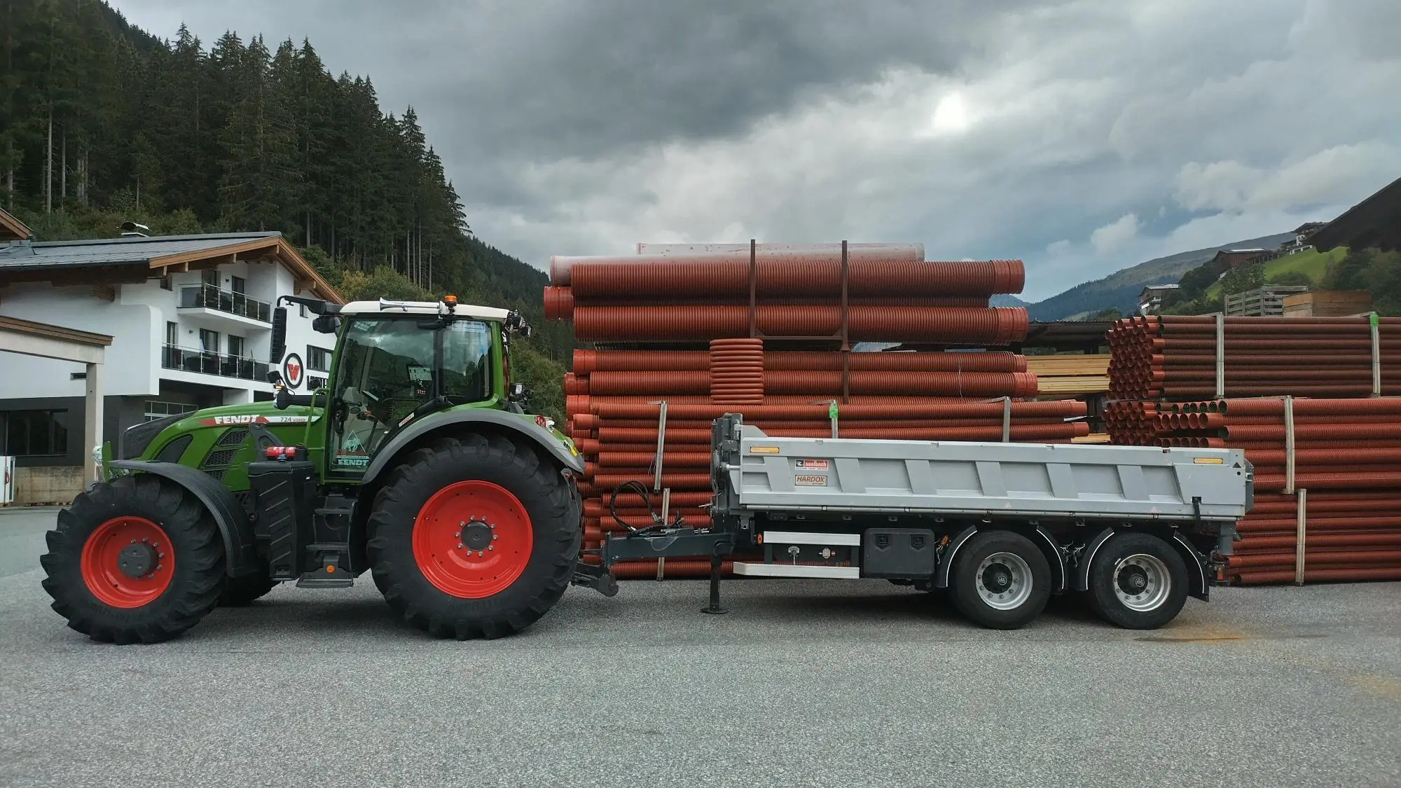 Fendt 724 Vario coupled to a Saalbach three-way tipper trailer, mountains in the background